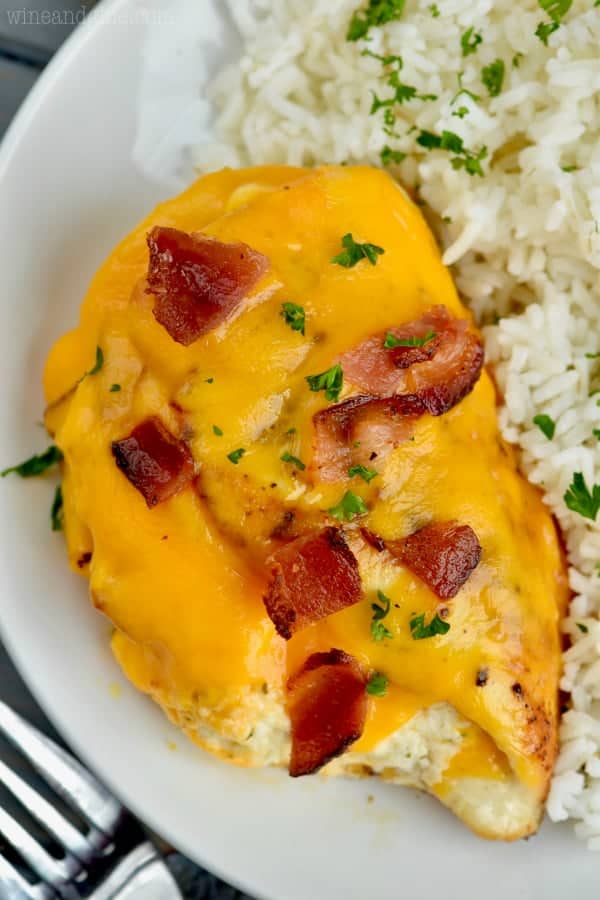 bacon cheddar ranch stuffed chicken breasts up close on white plate with rice on the side