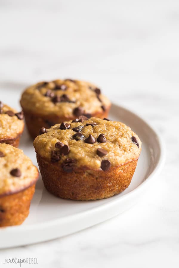 banana oat muffins close up on white plate with muffin in the background