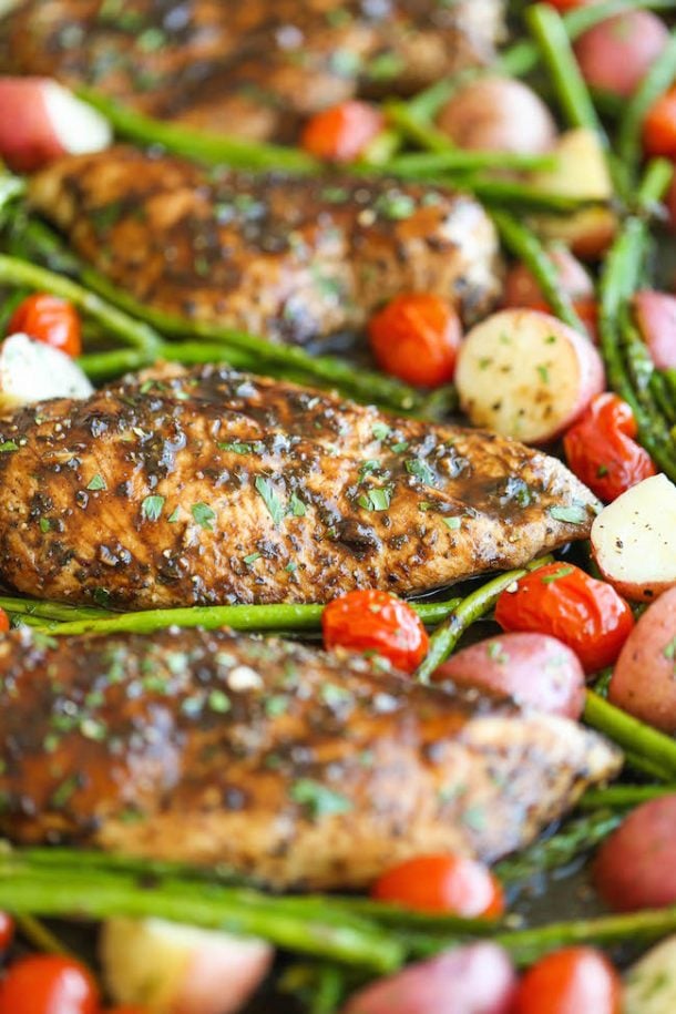 honey balsamic chicken breasts with potatoes tomatoes and green beans lined up on a sheet pan