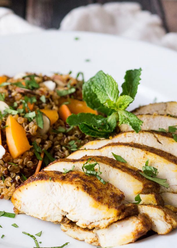 moroccan baked chicken breast close up on plate sliced with mint sprig on top