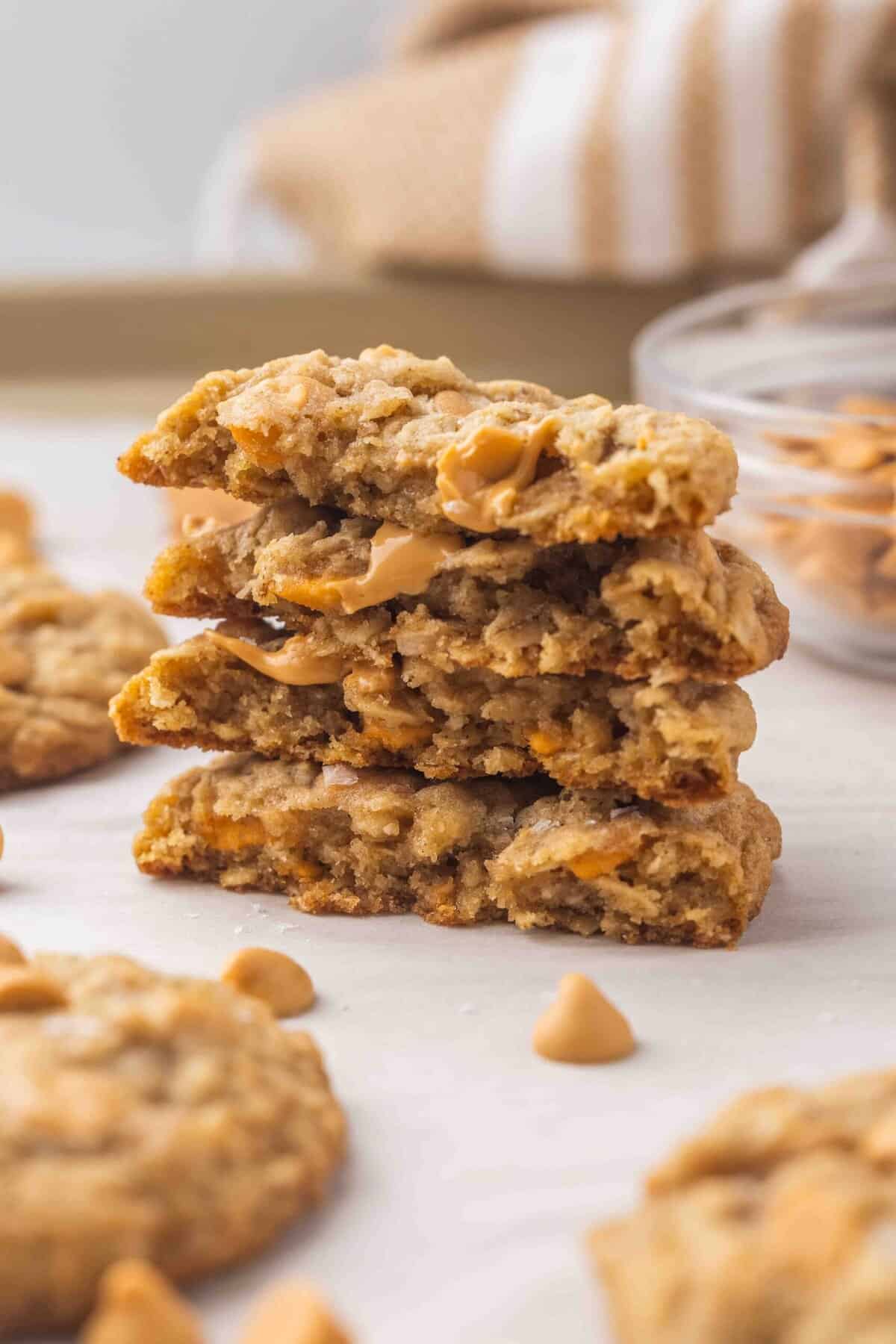 These Oatmeal Butterscotch Cookies (Oatmeal Scotchies) are soft, chewy, and loaded with butterscotch chips! Perfectly chewy and no chilling required! #cookie #recipe #baking | cookie recipes | oatmeal cookies | no chill cookies | easy cookie recipes | easy recipes | easy baking recipes stack of four broken oatmeal scotchies on a baking sheet.