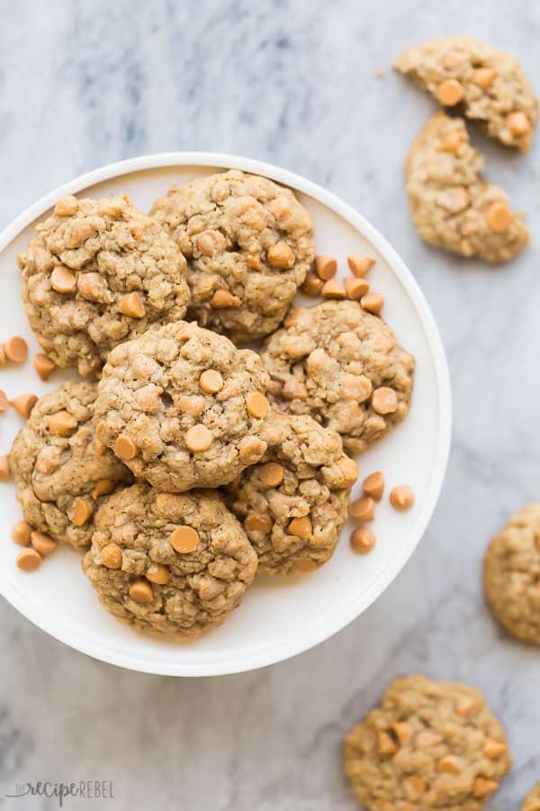 oatmeal butterscotch cookies overhead on white platter over grey marble background with broken cookies on the side