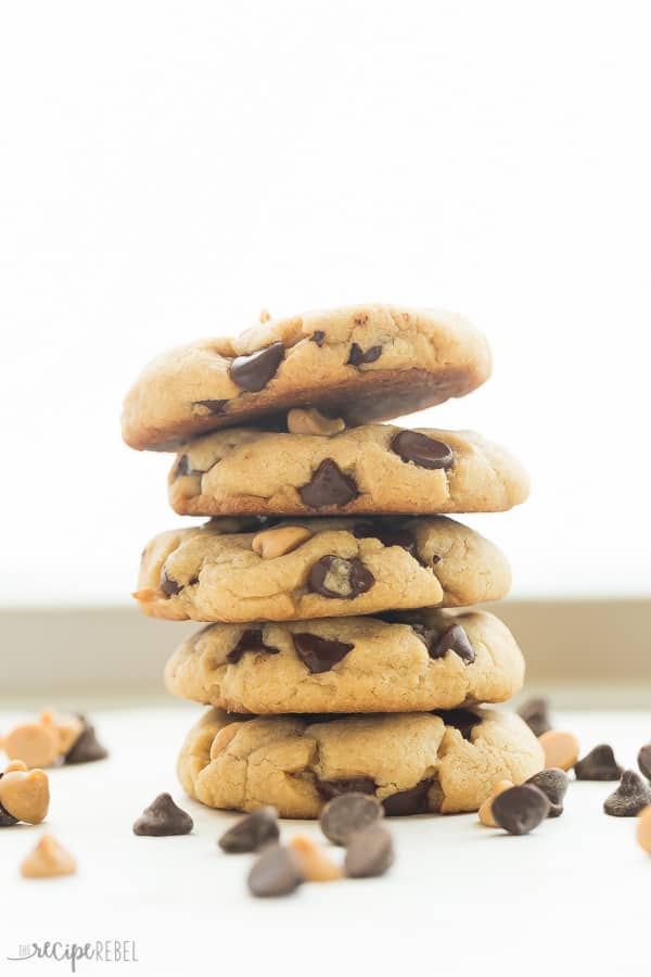 stack of peanut butter chocolate chip cookies with lots of chocolate and peanut butter chips all around