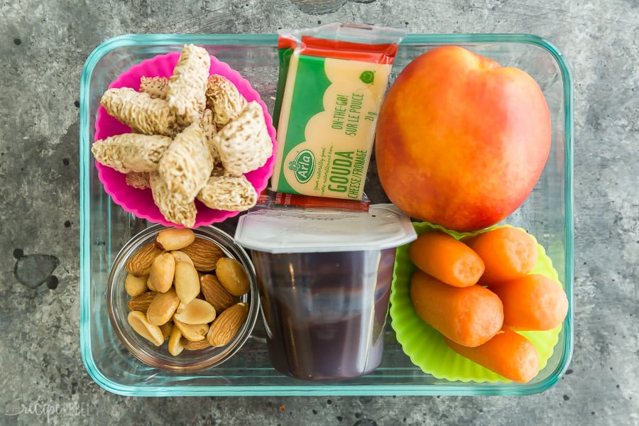 school lunch idea dry cereal in silicone cup with nuts and cheese bar plus chocolate pudding whole apple and baby carrots