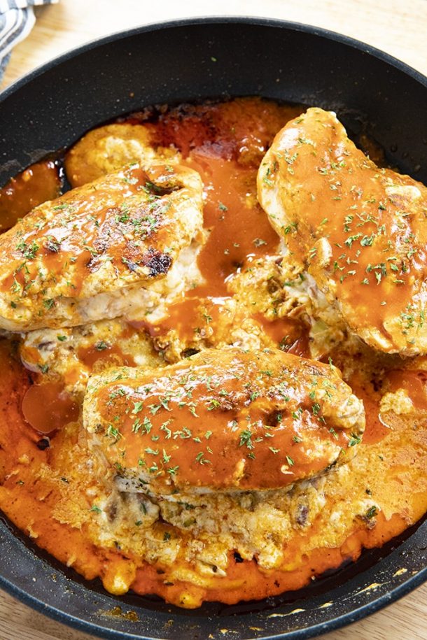  cheesy buffalo stuffed chicken breasts in black cast iron skillet