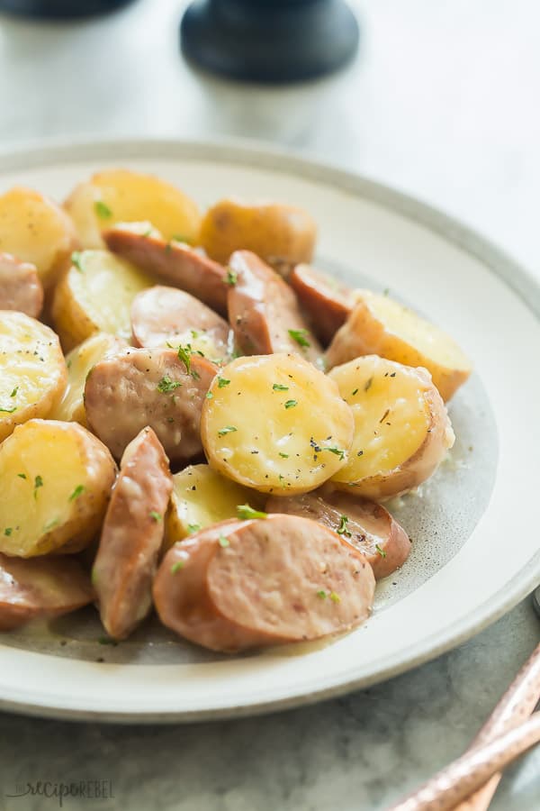 creamy sausage and potatoes plated up close with a sprinkle of dried parsley