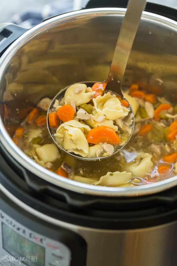 instant pot chicken tortellini soup in pot with metal scoop pulling up some soup
