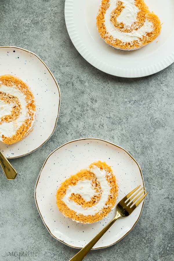 pumpkin roll sliced on white plates on grey background