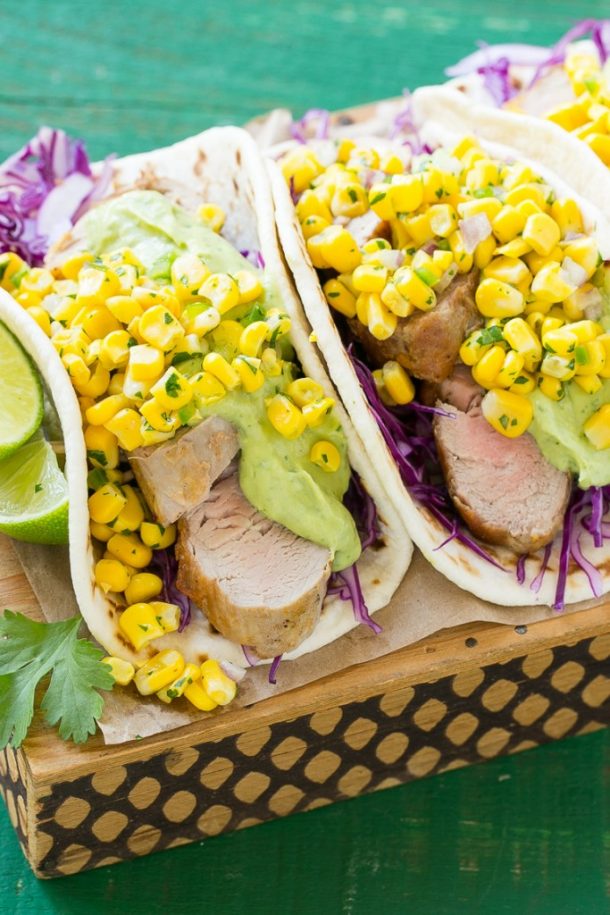 pork tenderloin taco recipe with corn salsa on top and red cabbage and avocado in the taco