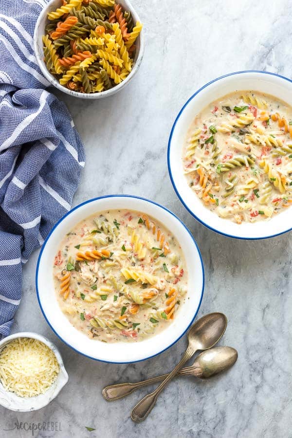 two bowls of crockpot chicken noodle soup on marble background