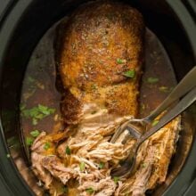 overhead image of slow cooker pork loin roast in black slow cooker