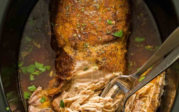 overhead image of slow cooker pork loin roast in black slow cooker