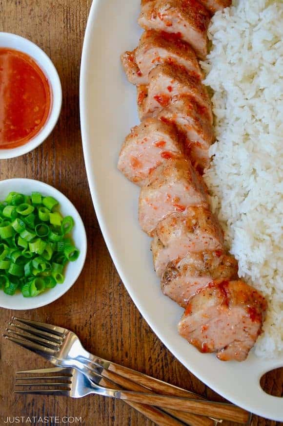 sweet and spicy pork tenderloin on a large white platter with white rice on the side