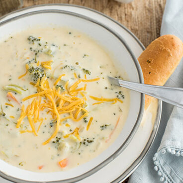 instant pot broccoli cheese soup with shredded cheese on top