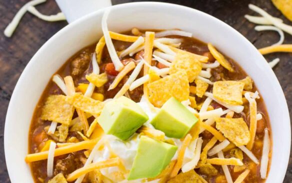 white bowl of instant pot taco soup with cheese on top
