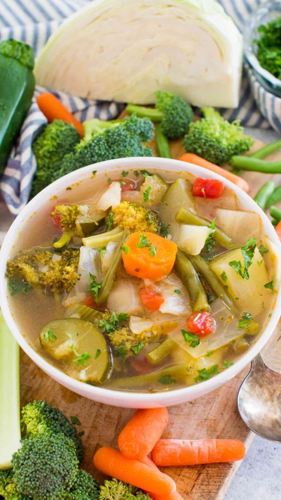 instant pot weight loss soup in white bowl with lots of vegetables in the background