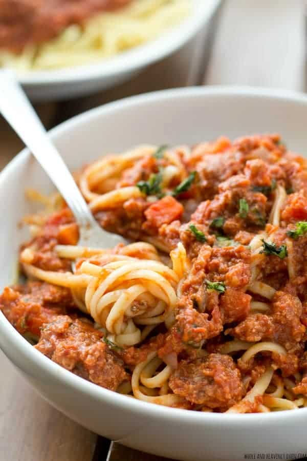 ground beef crock pot bolognese close up in bowl with spaghetti and fork stuck into pasta