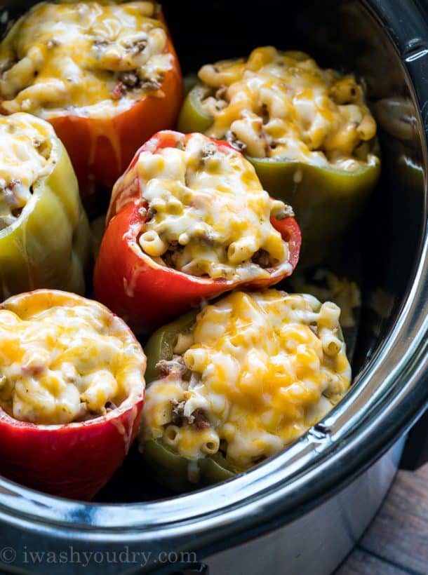 ground beef crock pot stuffed peppers in black crockpot with lots of melted cheese on top