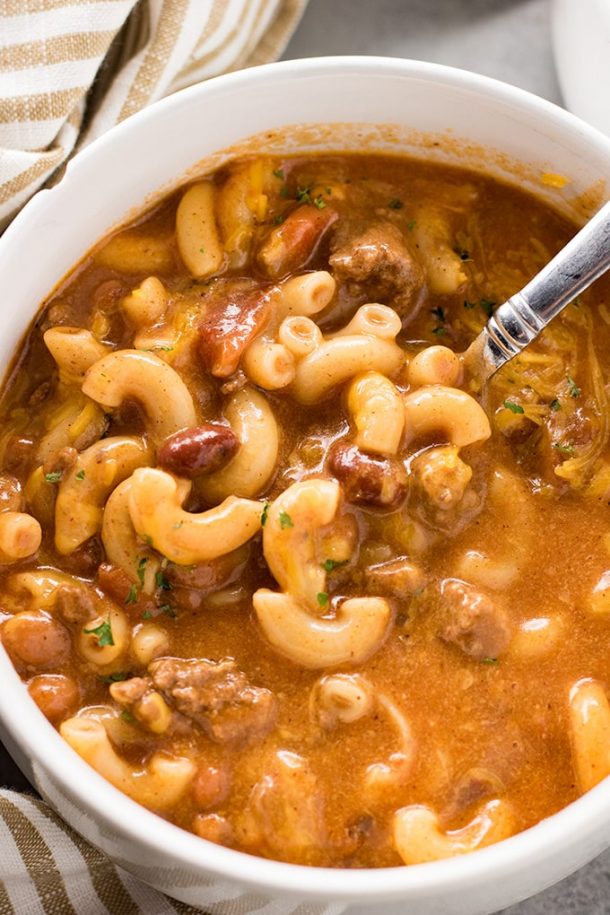 ground beef crock pot chili macaroni soup very close up image with metal spoon stuck into soup