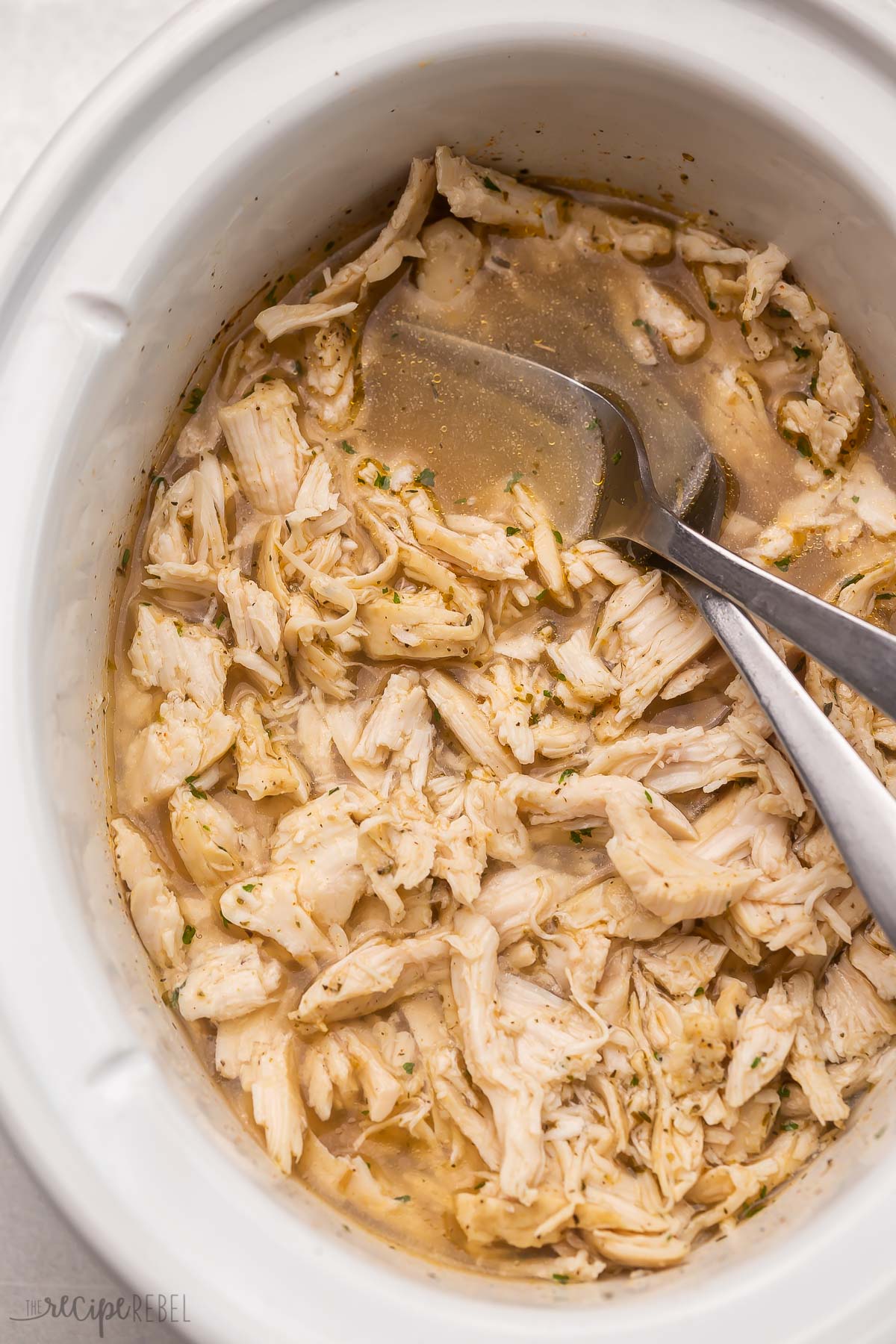 crockpot pulled chicken with two forks.