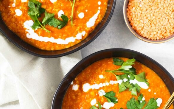 curried lentil soup in two black bowls