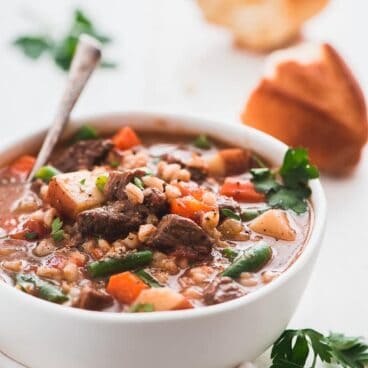 bowl of instant pot beef barley soup with a spoon in