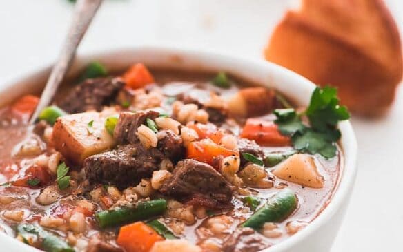 bowl of instant pot beef barley soup with a spoon in