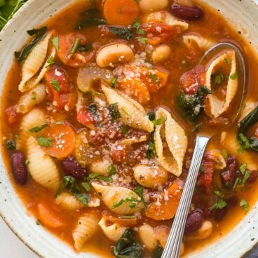 overhead close up image of minestrone soup in bowl with spoon