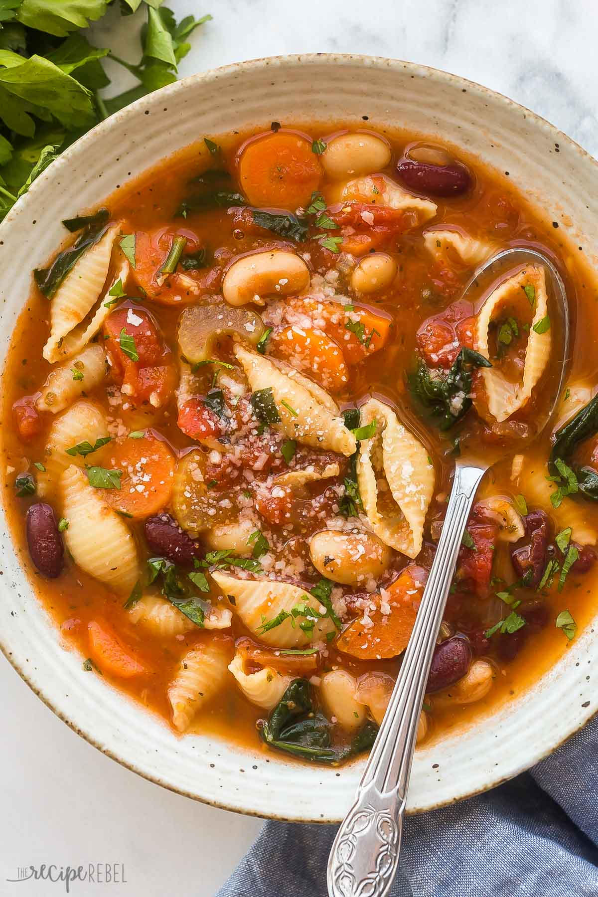 overhead close up image of minestrone soup in bowl with spoon