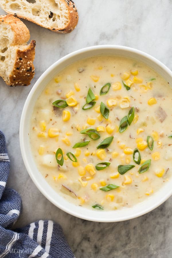 potato corn chowder recipe overhead in white bowl with green onions on top