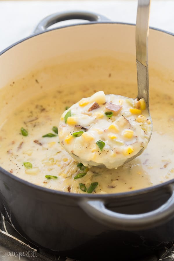 potato corn chowder in grey dutch oven with one scoop being scooped in metal ladle