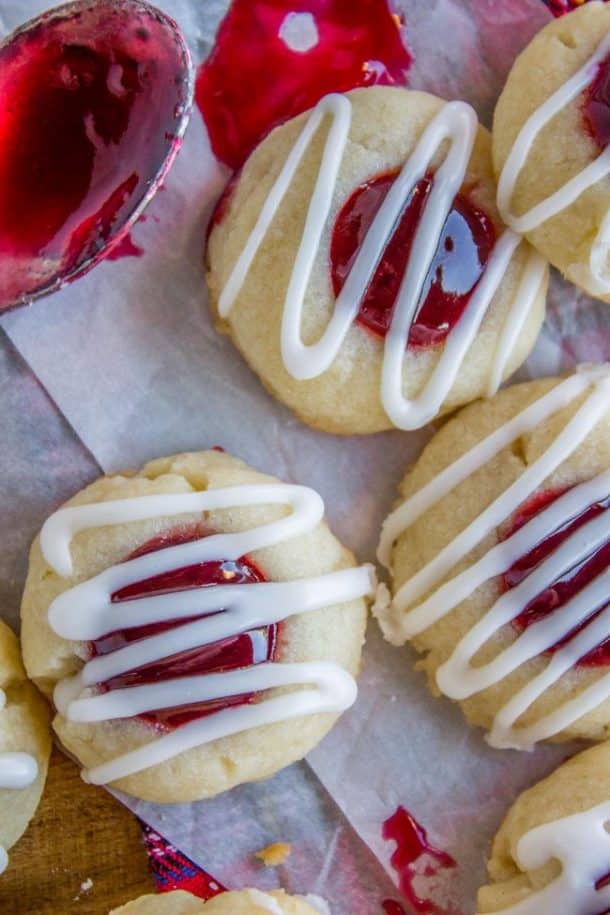 raspberry almond thumbprint cookies up close with white frosting drizzle