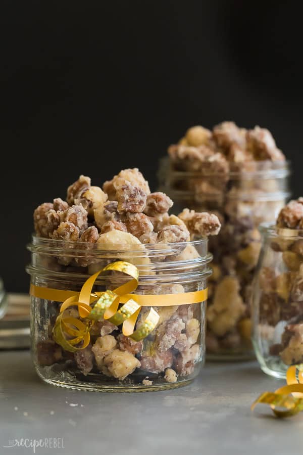 candied nuts in jar wrapped with gold ribbon on black background
