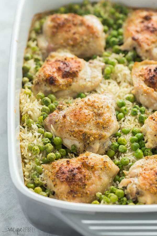 chicken and rice bake in casserole dish close up of crispy chicken thigh skin and rice with peas