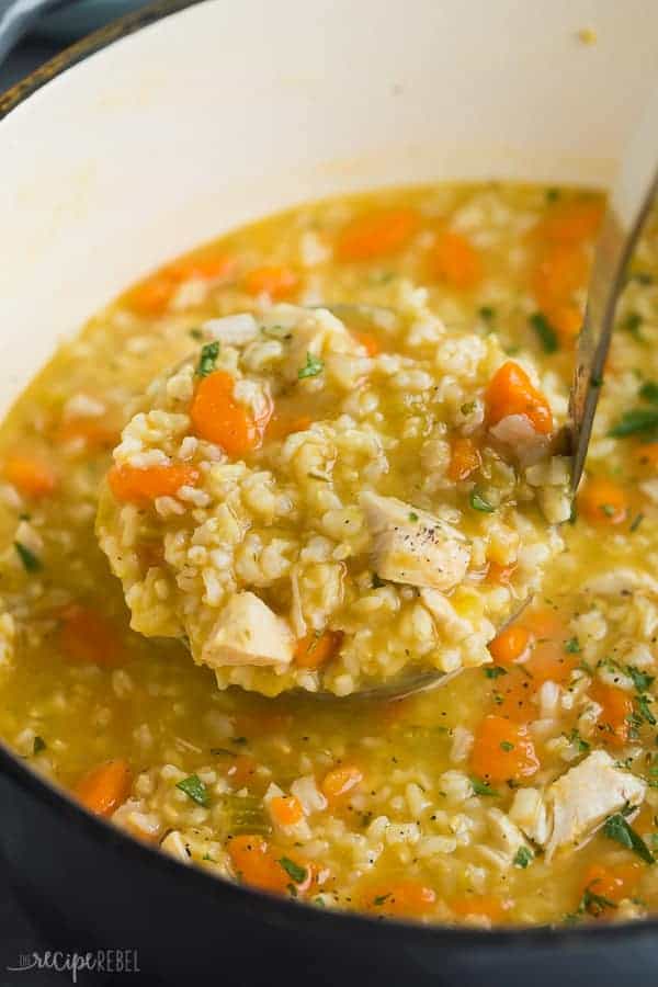 scoop of chicken rice soup close up in dutch oven