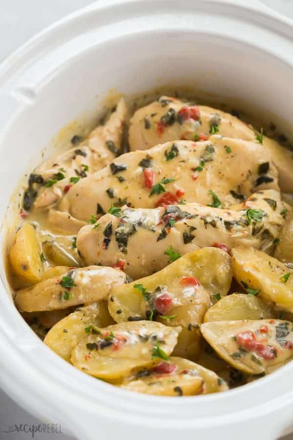 crockpot chicken and potatoes in slow cooker with spinach and roasted red peppers