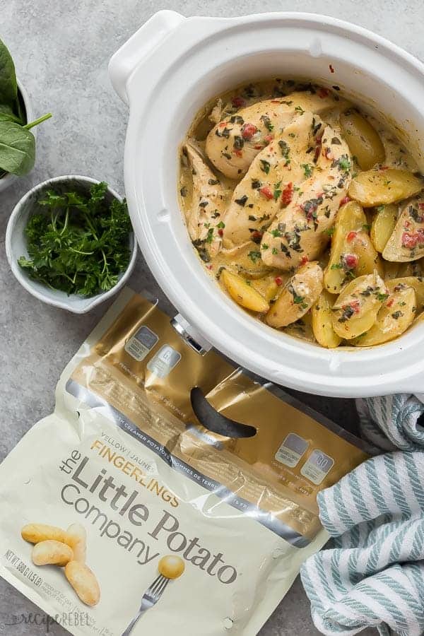 crockpot chicken and potatoes overhead with fresh parsley on the side and bag of little potatoes