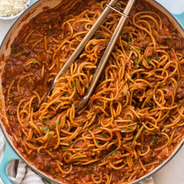 overhead image of one pot spaghetti with tongs stuck in