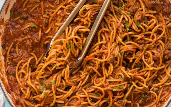 overhead image of one pot spaghetti with tongs stuck in