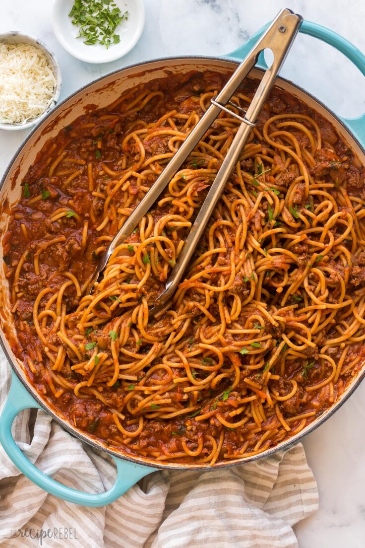 overhead image of one pot spaghetti with tongs stuck in