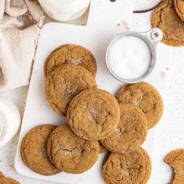 overhead image of molasses cookies with bottles of milk around.