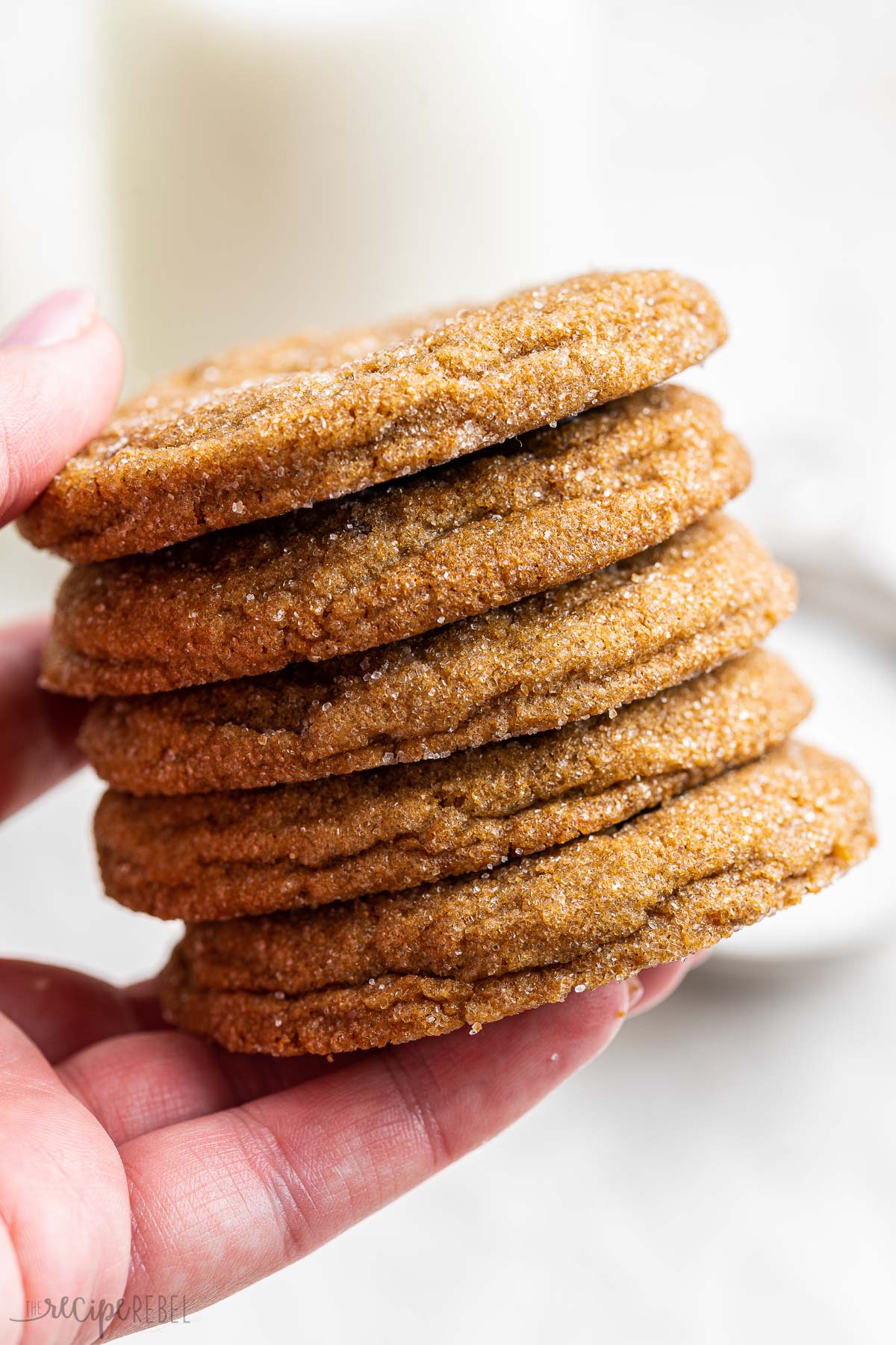 stack of five molasses cookies held in hand.