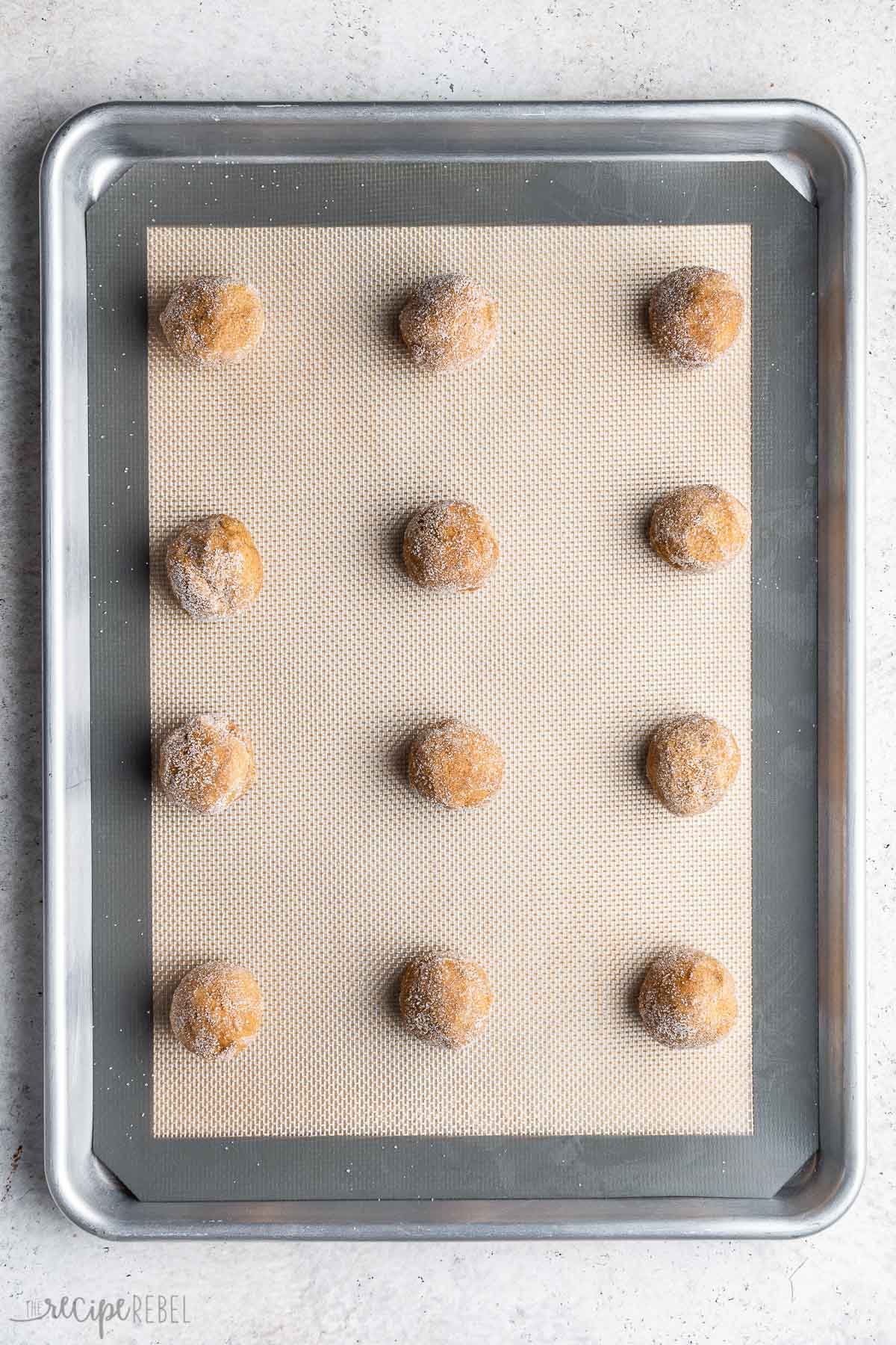 molasses cookies rolled in sugar on baking sheet.