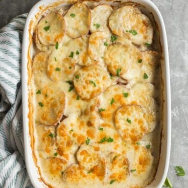 cheesy scalloped potatoes and ham in white dish