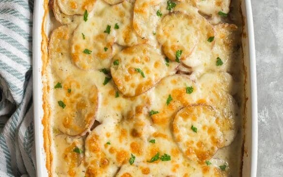 cheesy scalloped potatoes and ham in white dish