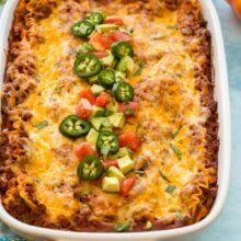 close up image of taco lasagna with avocado jalapenos and tomatoes