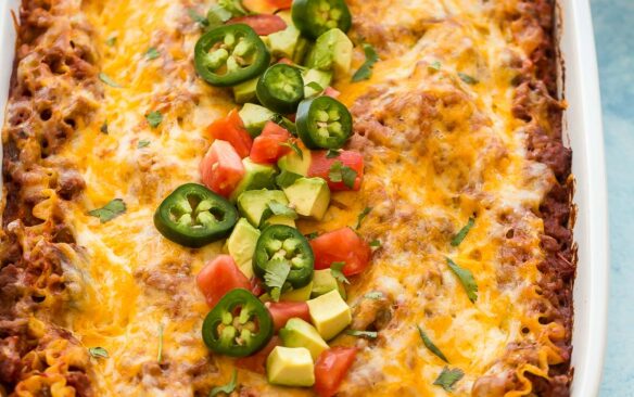 close up image of taco lasagna with avocado jalapenos and tomatoes