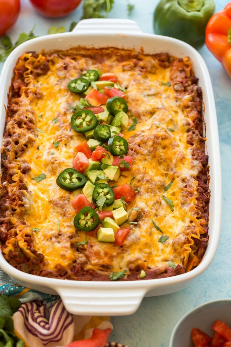 close up image of taco lasagna with avocado jalapenos and tomatoes