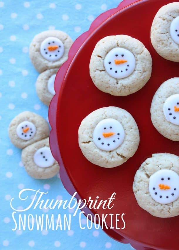 snowman thumbprint christmas cookies with white filling and snowman face on the filling