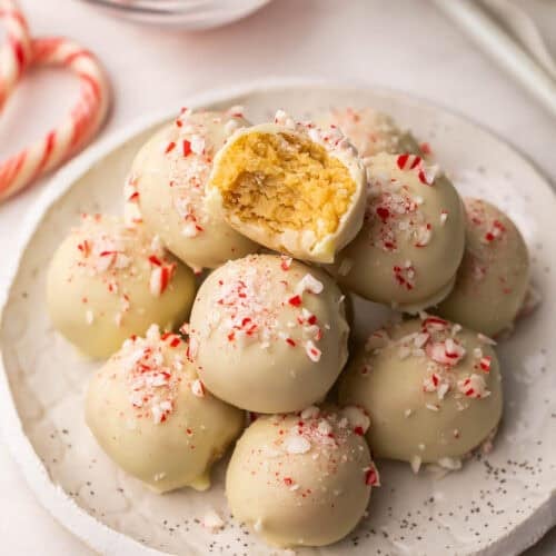white chocolate peppermint oreo truffles on a white plate with a bite out.